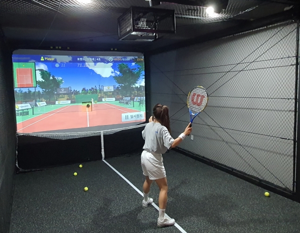 실내 테니스장을 방문한 고객이 스크린 테니스를 즐기고 있다.